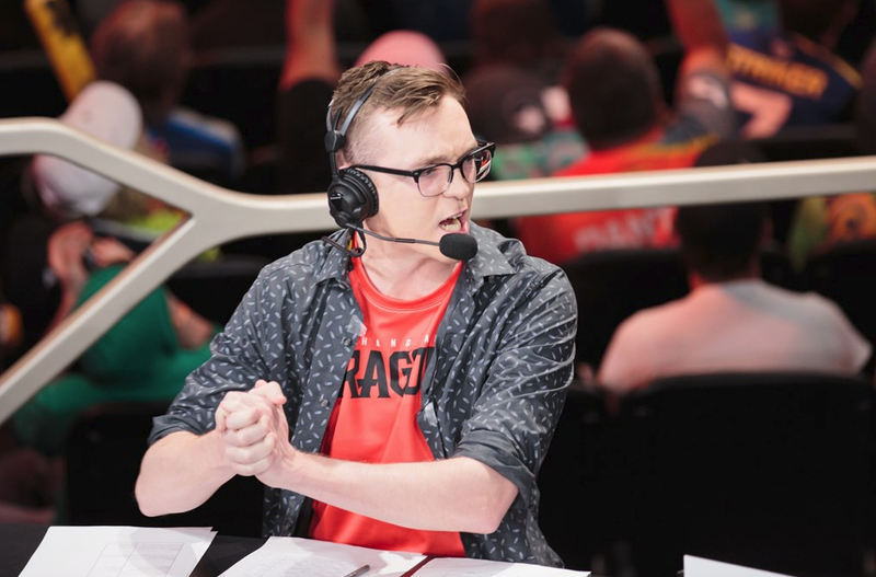 An Overwatch League caster wearing a Shanghai Dragons shirt.